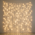 Warm white LED curtain lights glowing against a pale wall