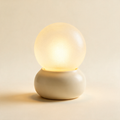 The Bedside touch table lamp with a cream base and warm glowing globe