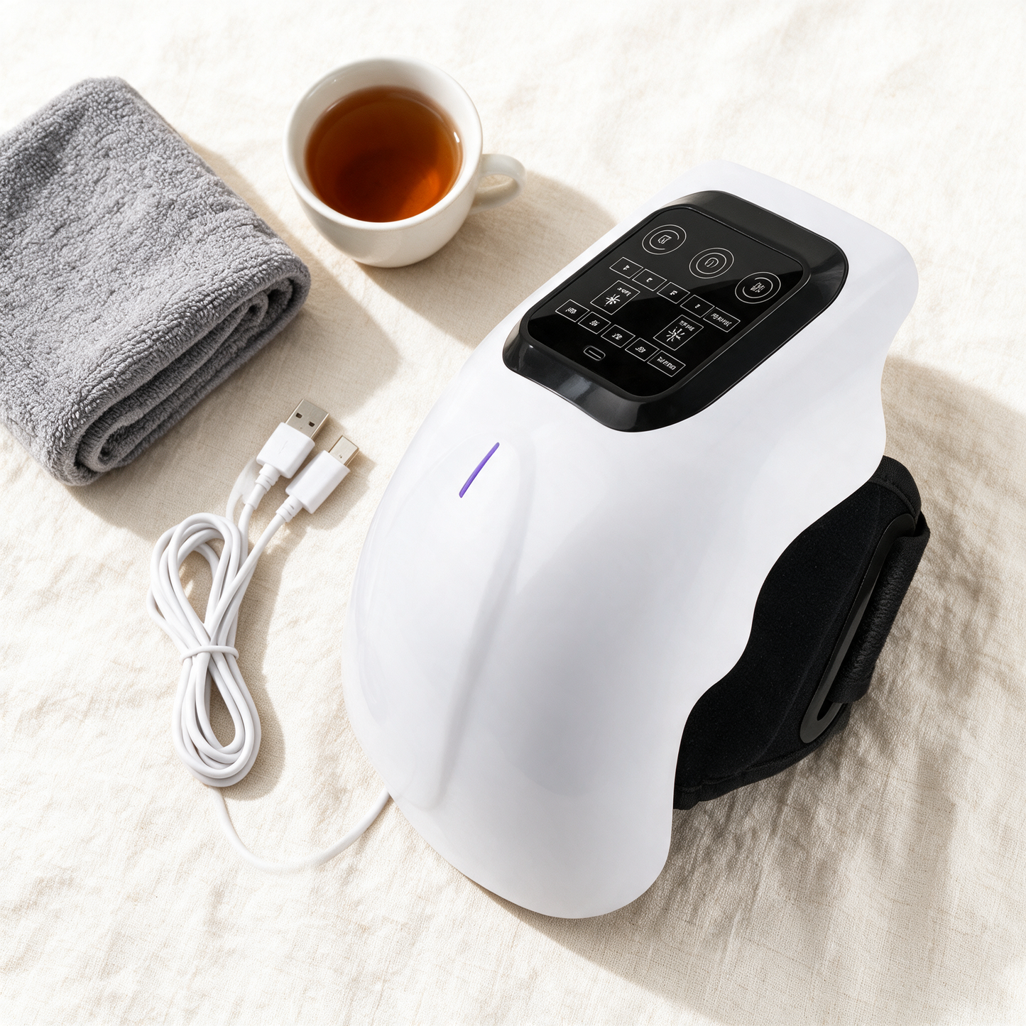 KneeEase flat lay with USB-C cable, towel and tea
