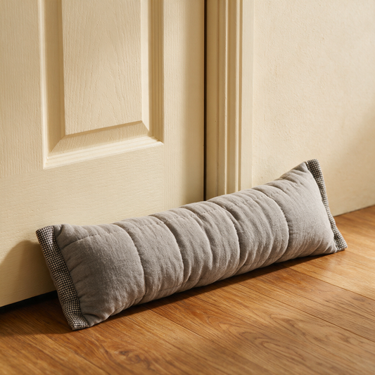 The Draughtsman grey door draught excluder against a door