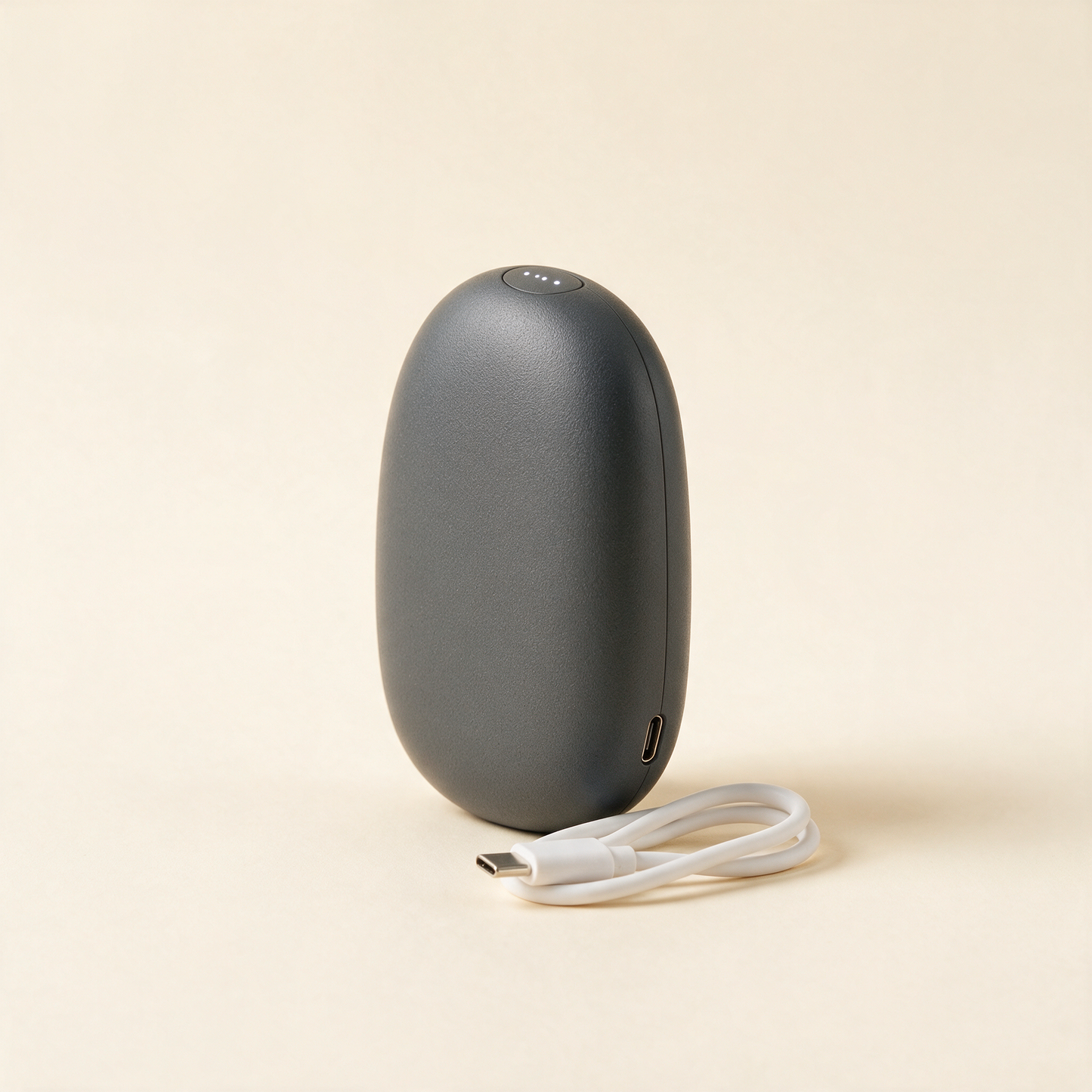HeatPod hand warmer standing upright with USB C cable
