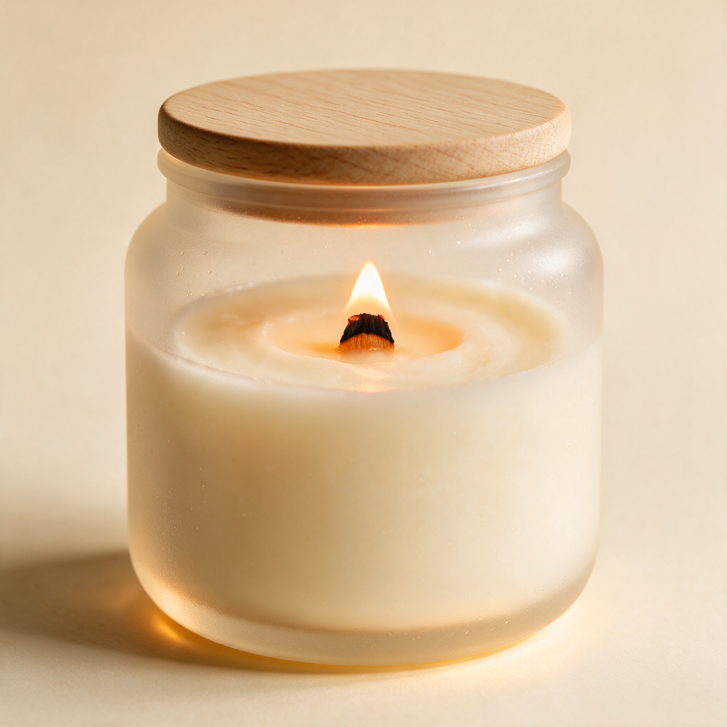 Close-up of a lit soy candle from The Retreat trio with wooden lid