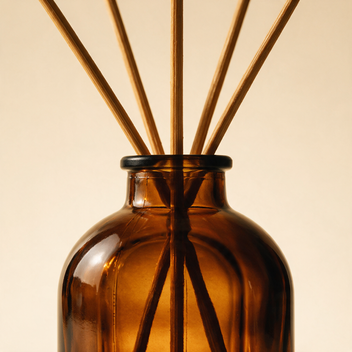 Close-up of The Haven amber bottle with black cap and natural reeds