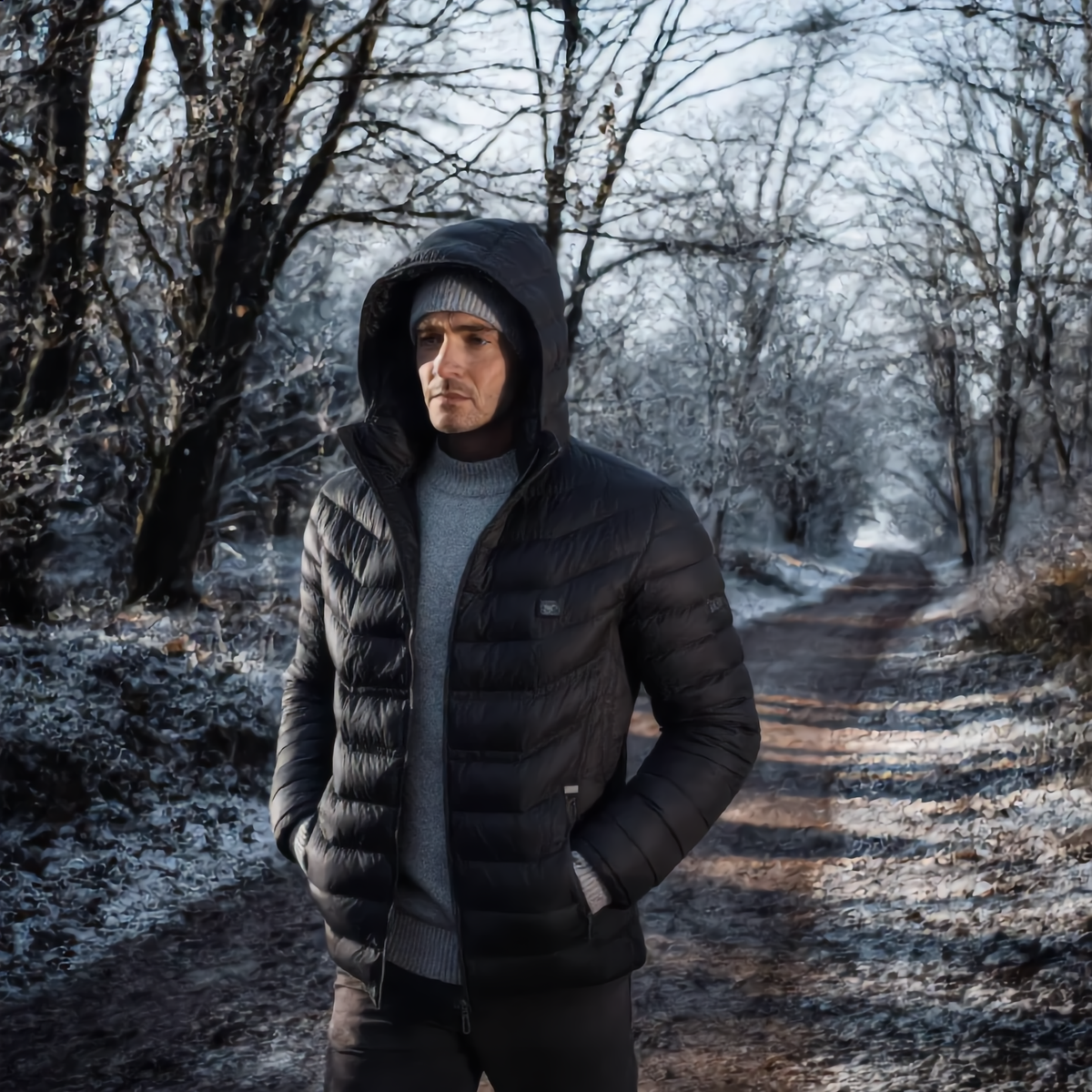 Man wearing the heated jacket on a frosty woodland path