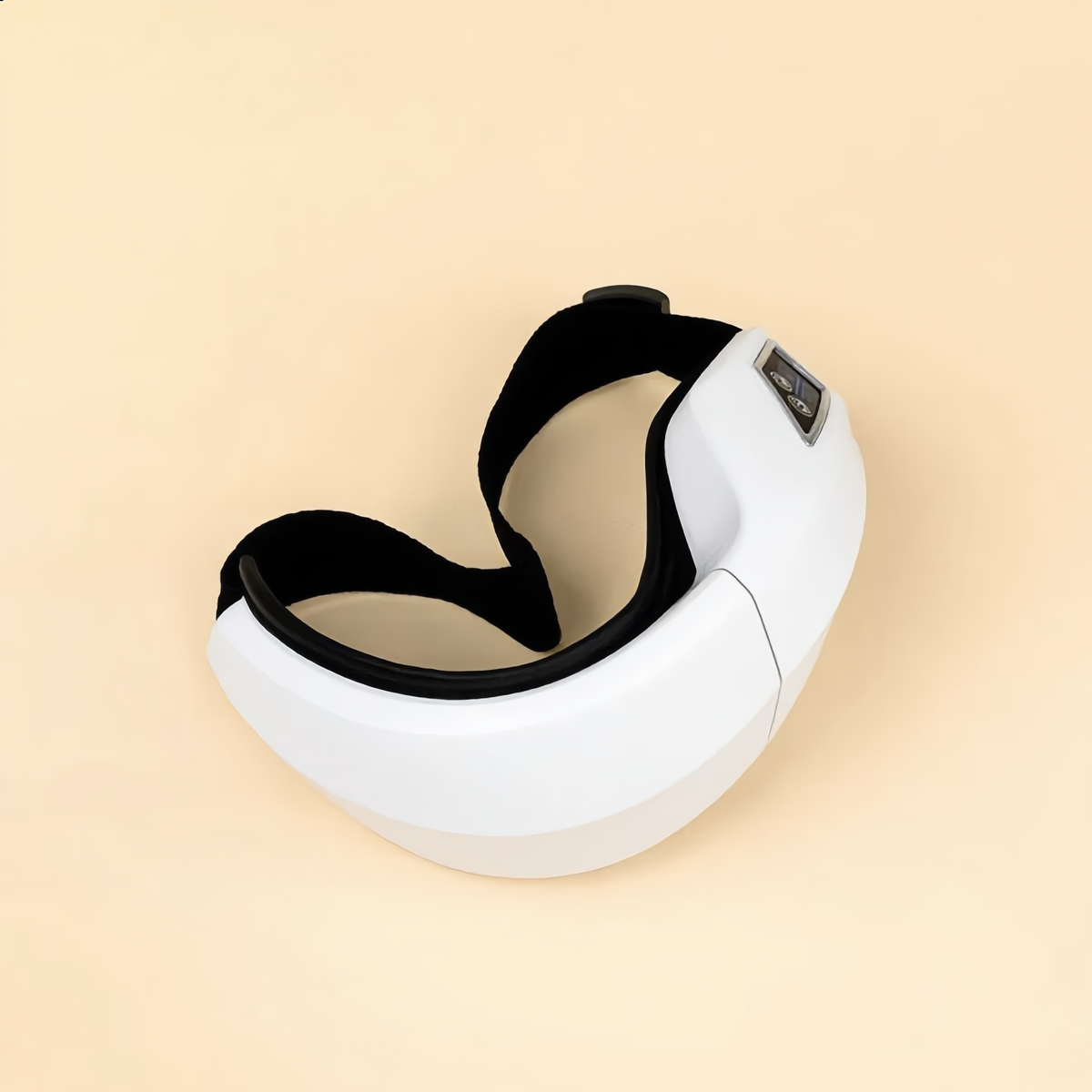 Eye massager folded flat with the strap coiled beside it