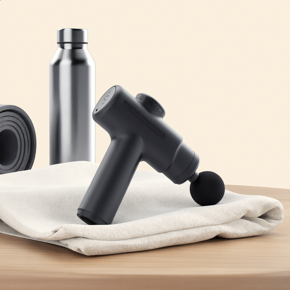 Massage gun on a folded towel with a water bottle