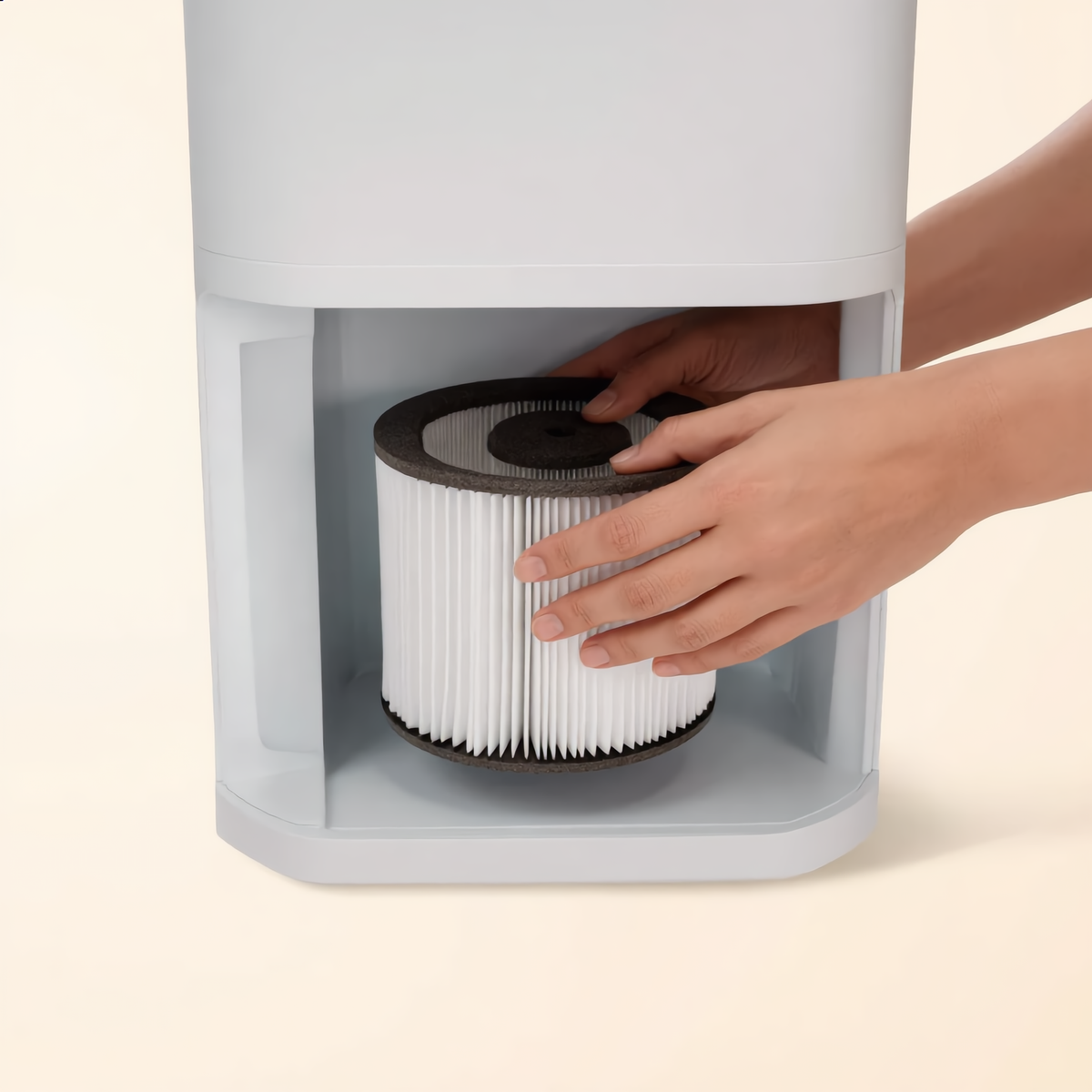 Hands lifting the HEPA filter cartridge out of the base